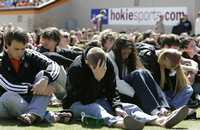 Estudiantes de la Universidad Virginia Tech durante un servicio religioso en el estadio de futbol del plantel, en memoria de las víctimas del ataque perpetrado la mañana del lunes