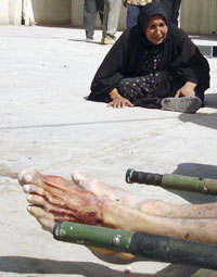 Una iraquí observa en Baquba el cuerpo de su hijo asesinado por un comando armado.