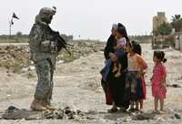 Un soldado estadunidense y una familia iraquí durante un patrullaje en Mahmudiya, al sur de la capital de Irak