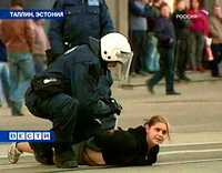 Imagen de la televisora RTR de Moscú que muestra a un agente de la policía cuando detiene en Tallin, capital de la república báltica de Estonia, a una joven de ascendencia rusa
