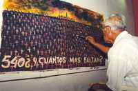 En imagen de archivo, un hombre hace una pintura alusiva al desastre en Anaversa, el cual ha causado hasta la fecha al menos mil 500 muertes por cáncer