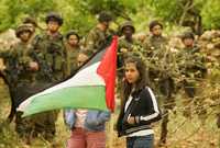 Dos jóvenes palestinas se manifestaron este viernes contra un muro que construye Israel en Cisjordania