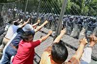 Un grupo de mentores arremete contra la valla metálica colocada para impedir su acceso a la residencia oficial de Los Pinos