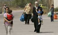 Familia palestina huye de la violencia en la franja de Gaza y cruza por la ciudad de Erez hacia Irsael