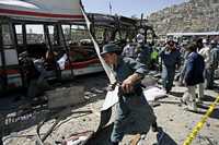 Elementos de seguridad examinan el sitio de la explosión en Kabul. Se presume que un atacante suicida acciónó la bomba dentro del vehículo que transportaba a agentes de la policía