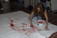 La artista plástica Rosa María Robles en el momento de aplicar su sangre sobre cobijas para sustituir las que fue fueron retiradas por la policía