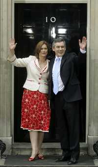 Gordon Brown, nuevo primer ministro de Gran Bretaña, saluda a reporteros a la entrada del emblemático 10 de Downing Street, residencia de los gobernantes británicos. Lo acompaña su esposa, Sarah