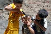 Dos menores iraquíes simulan que asesinan a otro de cuatro años, ayer en Bagdad. En este país los juegos de los niños están gravemente influidos por la violencia. Una de las diversiones preferidas es en la que se enfrentan milicianos y policías