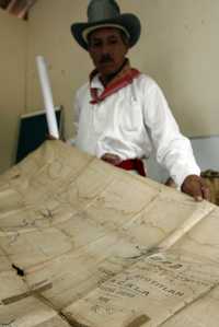 El representante del consejo de mayores de la zona nahua de Ayotitlán, Gaudencio Roblado Mancilla, muestra uno de los mapas que señalan los límites territoriales del ejido