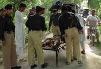 Policías paquistaníes examinan el cadáver de uno de sus compañeros, quien pereció ayer, durante un atentado suicida en el distrito de Dera Ismail Khan. Los atacantes hicieron estallar explosivos en el noroeste de Pakistán, una zona fronteriza con Afganistán, y provocaron la muerte de más de 38 personas