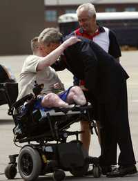 El presidente George W. Bush saluda al sargento James Kevin Downs, a quien le amputaron ambas piernas tras resultar herido en Irak. El soldado llegó ayer a Nashville, Tennessee. Los observa el padre del militar
