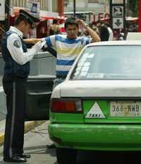 Un policía de tránsito levanta una multa a un taxista por invadir el paso de peatones, en avenida Insurgentes y Baja California, ayer domingo
