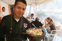 Rubén Corona muestra una de las especialidades de la casa: mariscos con salsa agridulce, cebollas y pepinos, en molcajete