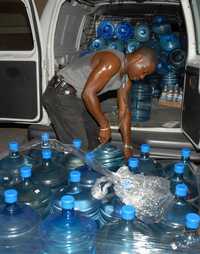 En Kingston un jamaiquino llena garrafones con agua potable
