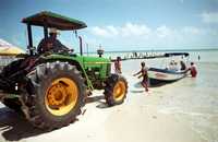 Con ayuda de un tractor -utilizado generalmente para limpiar las playas de Puerto Juárez y Puerto Morelos-, lancheros sacan de las aguas sus embarcaciones ante la posible llegada del huracán Dean a Quintana Roo