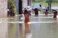 Policías municipales ayudan a una familia a rescatar algunas propiedades después de que muchas viviendas quedaron inundadas en la Laguna Negra de la ciudad de Tixtla de Guerrero