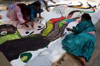 Indígenas mazahuas que radican en el DF  pintan una manta antes de la ceremonia que encabezó ayer Marcelo Ebrard en la plaza Luis Cabrera, en la colonia Roma