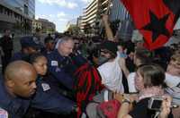 Manifestantes son empujados por efectivos policiacos en la barrera instalada frente a la sede del Banco Mundial, durante una protesta contra éste y el Fondo Monetario Internacional efectuada ayer en Washington
