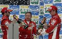 Kimi Raikkonen (derecha) y su coequipero Felipe Massa (izquierda) celebran con Jean Todt, director deportivo de Ferrari, su sorpresivo triunfo