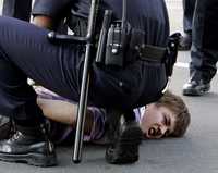 Policías someten a un manifestante que participaba en el bloqueo de una calle aledaña al Capitolio, en Washington, para protestar contra la guerra en Irak, en una jornada de desobediencia civil no violenta