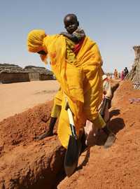 En El Fasher, norte de Darfur, una mujer cava una zanja en el campo de refugiados Dar al Salaam
