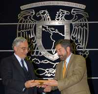 El rector Juan Ramón de la Fuente recibe de Javier de la Garza, representante de organismos externos, el reconocimiento a la UNAM por la acreditación de 89 programas y planes de estudio