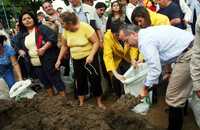 El presidente Felipe Calderón y su esposa, Margarita Zavala, ayudan a llenar costales de arena para contener el agua de los ríos que inundan Tabasco