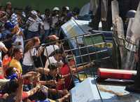 Estudiantes universitarios venezolanos contrarios a la reforma constitucional intentan romper una barrera formada por policías antimotines