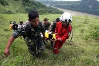 Soldados, marinos y socorristas trasladan a una señora que resultó herida tras el desprendimiento de un cerro en Chiapas