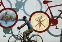 Un ciclista pasa ante un mural en una calle de la ciudad cubana de Cienfuegos