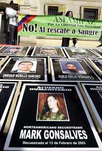 Carteles con las imágenes del estadunidense Mark Gonsalves y otros rehenes, todos ellos secuestrados por las FARC, son mostrados en Bogotá como protesta por la cancelación de la mediación para liberarlos