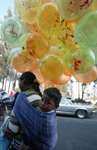 Una mujer mazahua, con su hijo a la espalda, vende globos que servirán de medio de transporte para las cartas de los pequeños