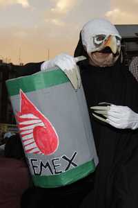 Un manifestante disfrazado de zopilote carga un falso barril de Pemex en la concentración contra el TLCAN del 31 de enero en el Zócalo capitalino