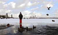 Estampa en el río Moskva, en Moscú: una niña sobre el hielo frente a un entusiasta nadador en invierno, conocidos en Rusia como morsas, disfruta el agua, que el domingo pasado registró una temperatura de un grado centígrado, y según los meteorólogos, debido a alta humedad y al viento, se siente como menos 5 grados centígrados