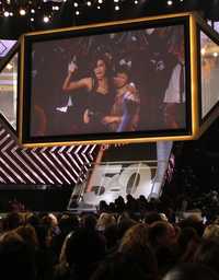 Amy Winehouse, a la izquierda, abraza a su madre al recibir su premio, en imagen vía satélite desde Londres