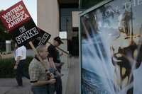Miembros del sindicato de escritores pasan frente a los estudios de la NBC en Burbank, California, donde se halla un cartel de la 80 entrega de los Óscares