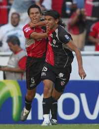El atlista Gerardo Flores (derecha) festeja con su compañero Ricardo Jiménez el gol con el que abrió el marcador ante los xeneizes