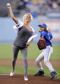 La actriz Pamela Anderson con su hijo Brandon Lee lanzan la primera bola del juego entre Dodgers de Los Ángeles y Astros de Houston el sábado por la noche