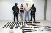 Policías federales flanquean a Zulema Iribe Sauceda y a Julio Alberto Zazueta Angulo, El Moti –presunto colaborador del Chapo Guzmán–, capturados en Culiacán, en posesión de armas de alto poder