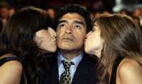 Maradona recibe un beso de sus hijas Giannina Dinorah y Dalma Nerea, en la presentación de la película en Cannes