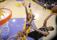 Tim Duncan de los Spurs, a la derecha, intenta clavar la pelota ante la doble defensa de Ronny Turiaf y Lamar Odom de Lakers