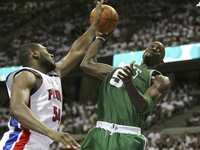 Kevin Garnett, de los Celtics de Boston, busca una canasta, mientras Jason Maxiell, de los Pistons de Detroit, intenta bloquearle el tiro