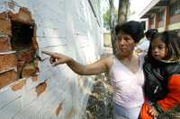 Una madre de familia muestra los daños en la estructura de uno de los edificios de la escuela primaria José Romero y Fuentes, pese a que las autoridades aseguran que el plantel ha sido rehabilitado en su totalidad