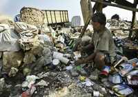 Un hombre escoge basura para reciclarla en las afueras de Yakarta, Indonesia. Los elevados precios de los combustibles y de los alimentos han presionado la inflación de muchos países en desarrollo