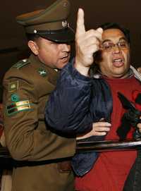 Un carabinero saca a empujones del recinto del Congreso chileno a un maestro