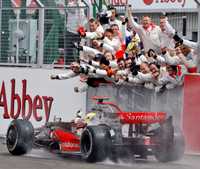 El piloto Hamilton, en su McLaren-Mercedes, es ovaciondo por la afición británica tras cruzar primero en la meta