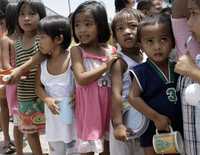 Varios niños hacen fila con tazas en la mano para recibir una porción de arroz que estudiantes voluntarios distribuyeron en barrios pobres de Manila, como forma de protestar ante la situación de hambre y pobreza en Filipinas. La inflación anual llegó a 11.4 por ciento en junio, el más alto nivel desde 1994
