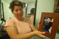 María Elena Saldaña muestra la foto de su hijo Jesús, quien recibió tres impactos de bala