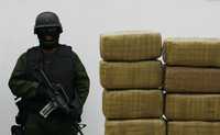 Un soldado vigila paquetes de mariguana que fueron encontrados en un auto abandonado cerca de las playas de Rosarito, en Baja California; la droga, unos 139 kilos en total, fue mostrada a la prensa en Tijuana