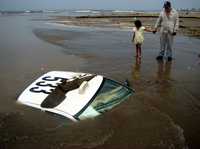 Un taxi quedó sepultado luego que su conductor, en medio de un aguacero, trató de cruzar un arroyo que desemboca en una playa de Veracruz. El taxista logró salir antes de que se hundiera su unidad